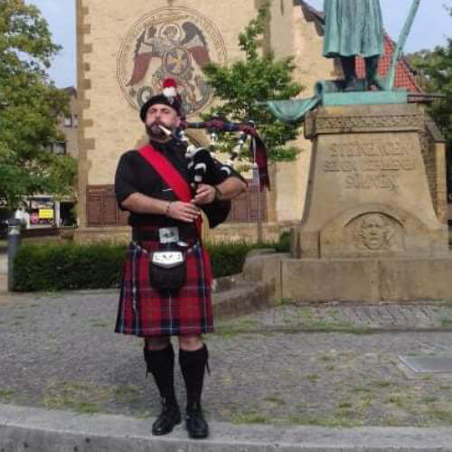 Ein Dudelsackspieler in Uniform spielt auf einer Familienfeier in Porta Westfalica